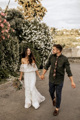 Les mariés qui marchent ensemble sur une route, mariage style boho, bouquet de mariée moderne, design floral Lilas Wood fleuriste mariage en Provence alpes côte d'azur - Photographie Chris and Ruth.