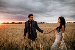 Les mariés dans un champs de blé, style boho, la mariée porte une robe moderne, design floral Lilas Wood fleuriste mariage en Provence alpes côte d'azur - Photographie Chris and Ruth.