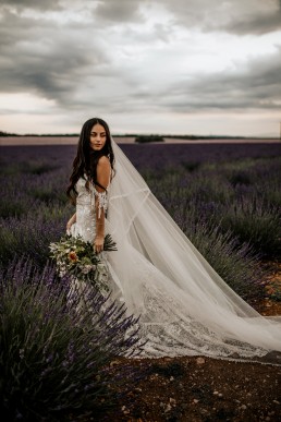 La mariée dans un champs de lavande, mariage style boho, elle porte un bouquet moderne, design floral Lilas Wood fleuriste mariage en Provence alpes côte d'azur - Photographie Chris and Ruth.