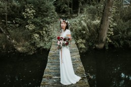 La mariée sur un pont de bois, couronne de fleurs et bouquet de la mariée confectionnés par LILAS WOOD - Fleuriste Mariage Dijon & Bourgogne.