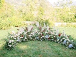 Laying on the ground of the Ceremony, forming a half circle around the bride and groom, made by the workshop LILAS WOOD, Floral Design & Wedding Florist Chambéry in Savoie (73) - Photographer Valéry VILLARD.